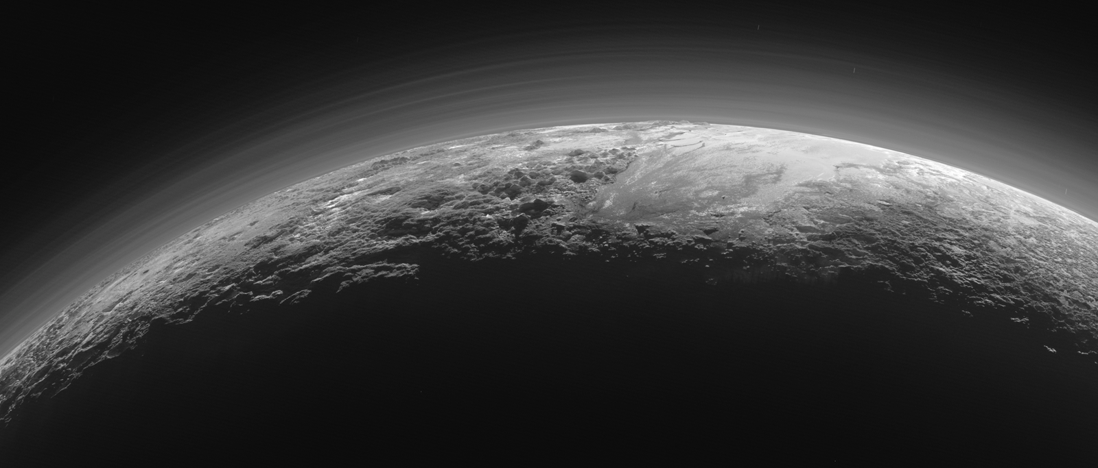 Un coucher de Soleil qui révèle la fine brume de Pluton, ses glaciers et ses majestueux sommets